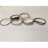 A collection of six bangles including silver and a
