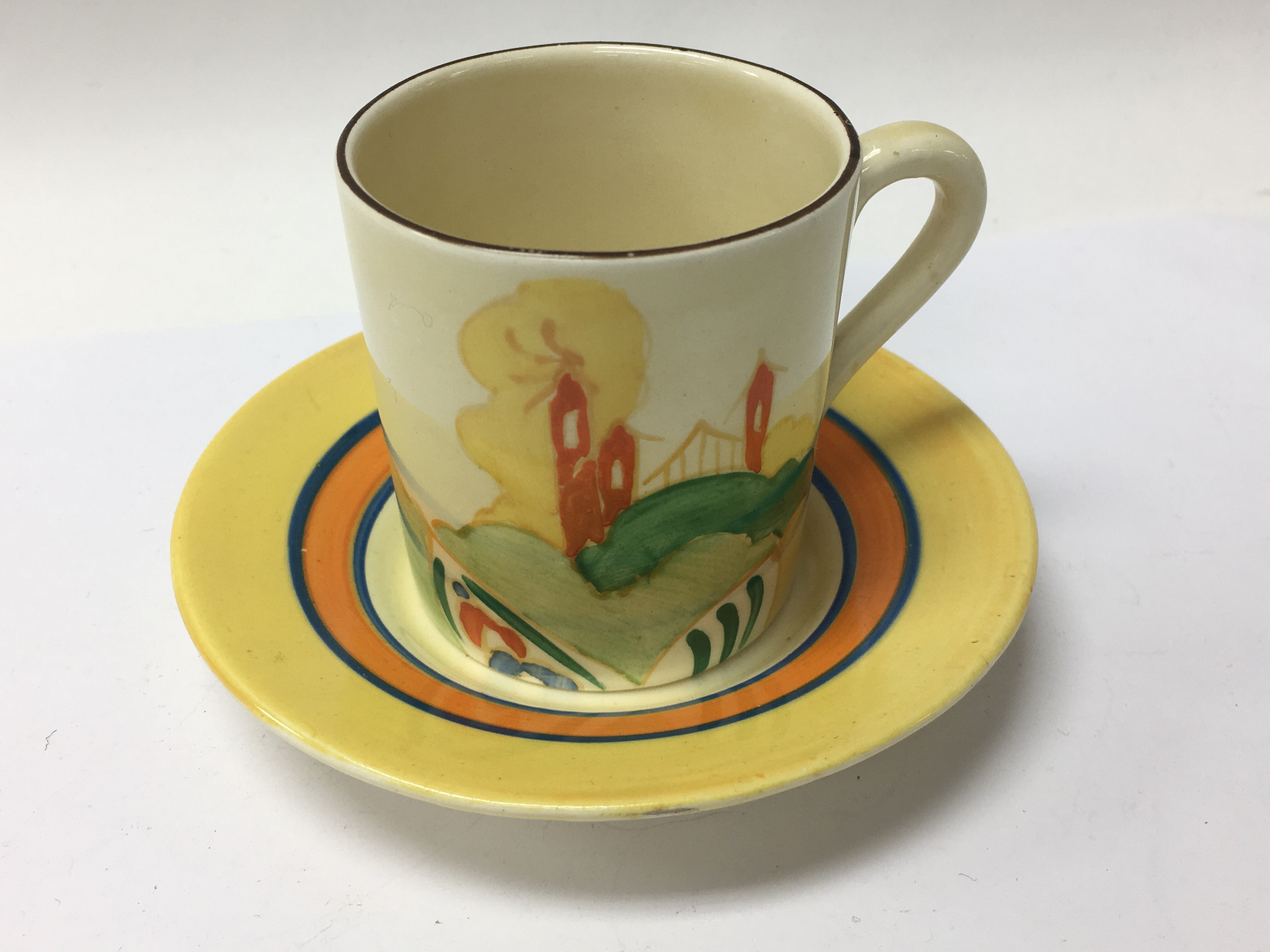 A Clarice Cliff coffee can and saucer alpine style