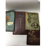 A collection of four postcard albums