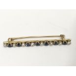 A 15ct gold bar brooch set with sapphires and pear