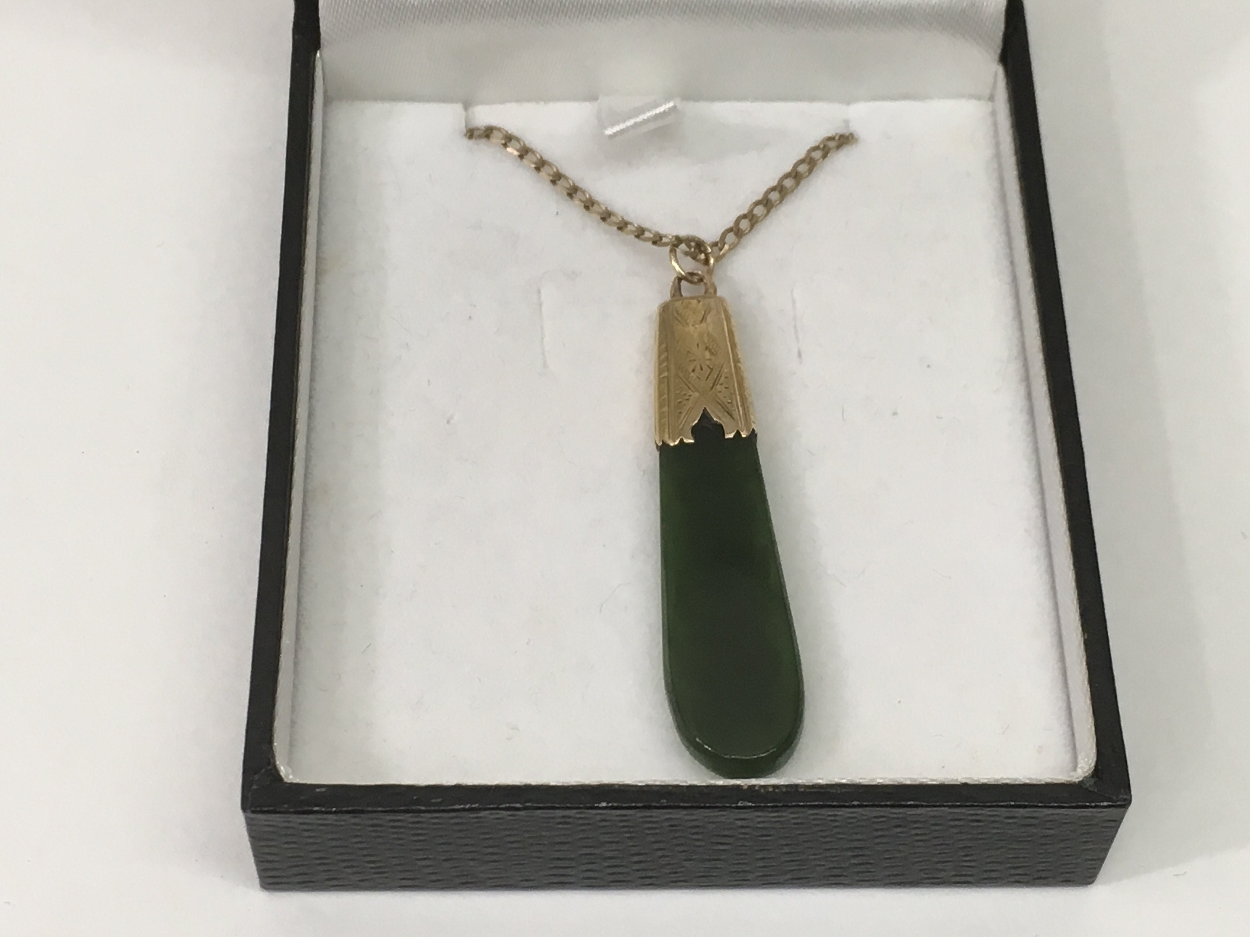 A 14ct gold and jade pendant on a 9ct gold chain.