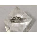 An 18ct white gold ring set with three diamonds, 1