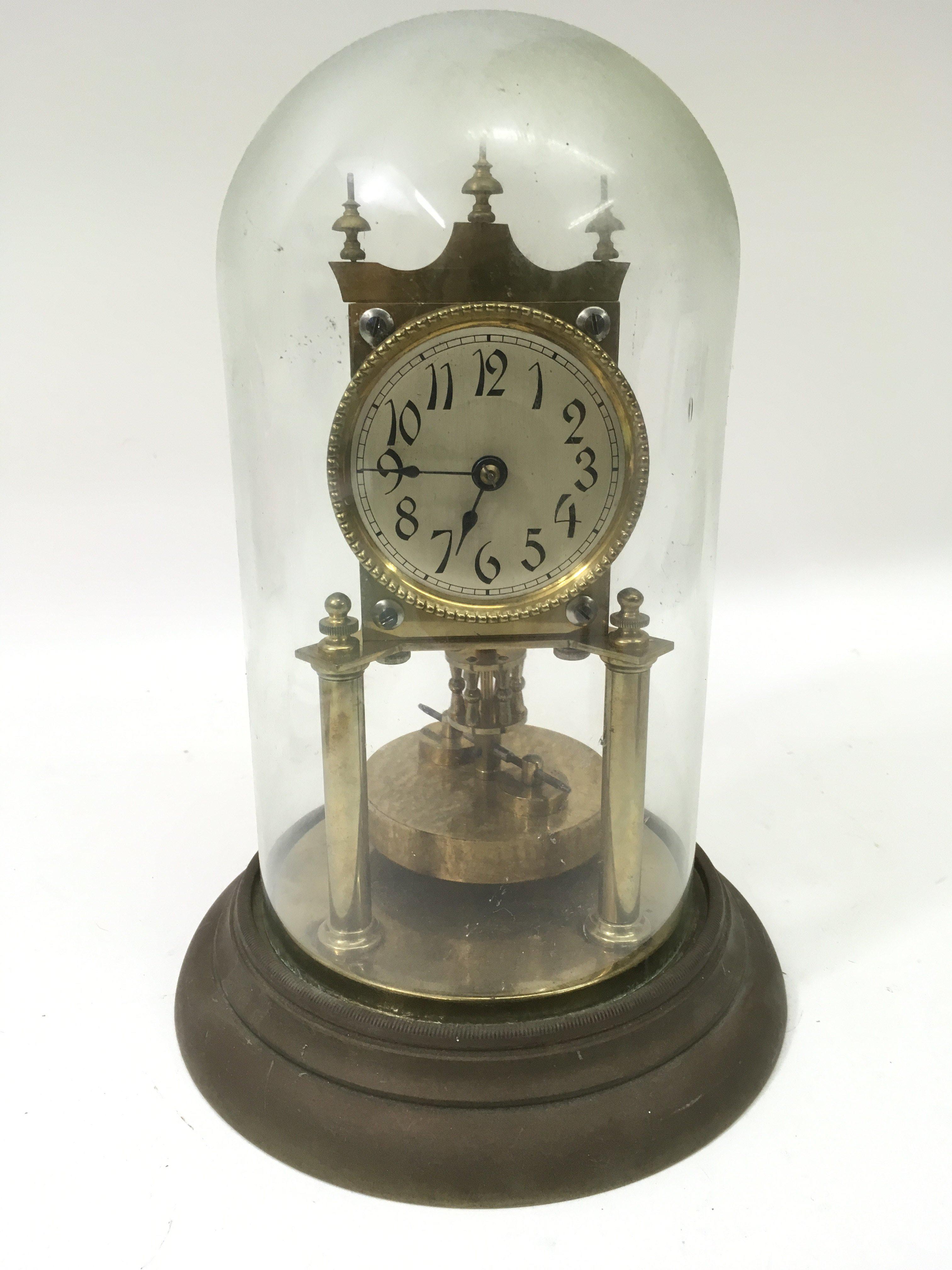 A brass skeleton clock under glass dome.Approx 30c