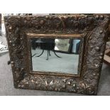 A cooper framed wall mirror with embossed floral decoration, approx 45cm x 38cm.