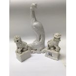 A pair of blanc de chine temple lions together with a blan de chine bird 30 cm