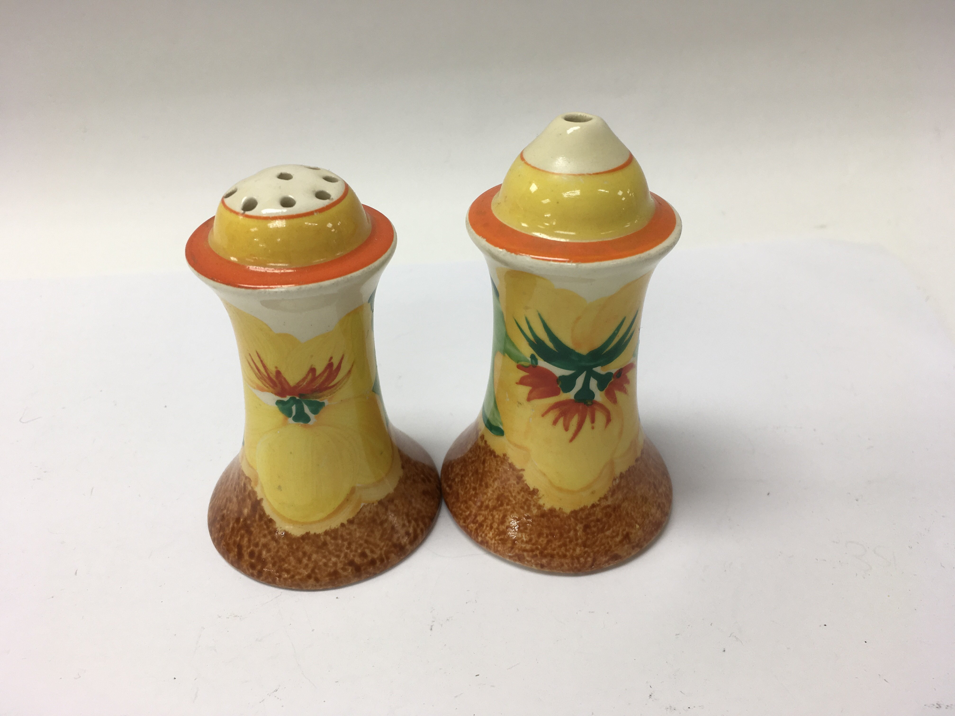 A pair of Clarice Cliff cruets decorated in the na