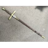 A sword with brass and wood handle in leather and brass sheath