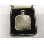 A cased silver perfume bottle with engraved scroll