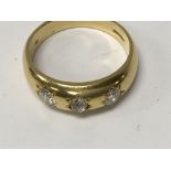 A 18 ct gold ring inset with three diamonds size x