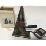 A cased Metronome a cast metal and painted paper s