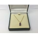A 9ct gold chain with an amethyst pendant, approx