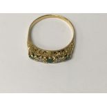 A unmarked gold ring inset with emerald and diamon