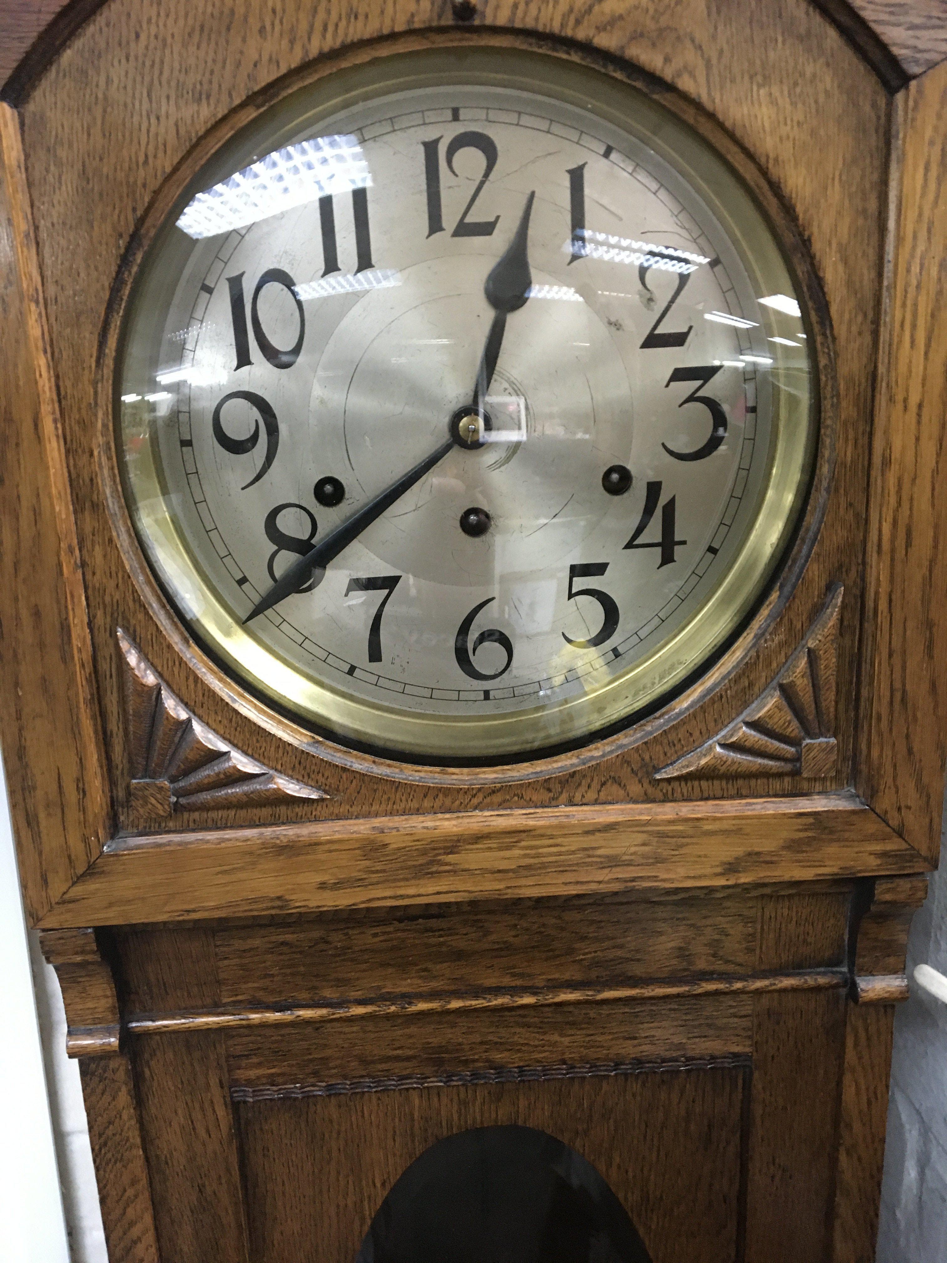 A oak cased grand mother clock the circular dial w