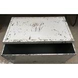 A vintage metal trunk with painted monogram to lid
