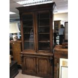 A Victorian Mahogany bookcase cupboard with an ove