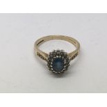 A 9ct gold ring set with a blue sapphire surrounde