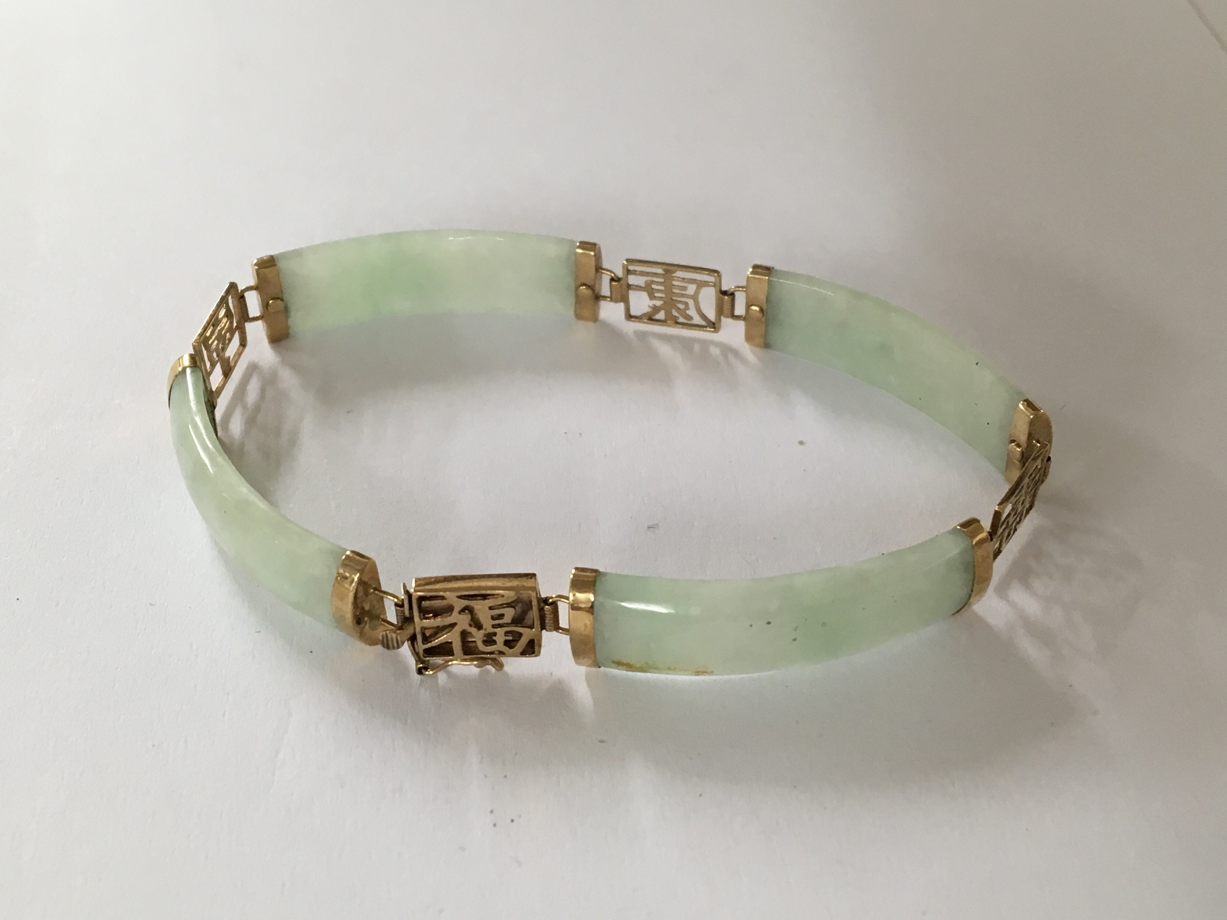 A jade bracelet with gold mounts