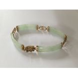 A jade bracelet with gold mounts