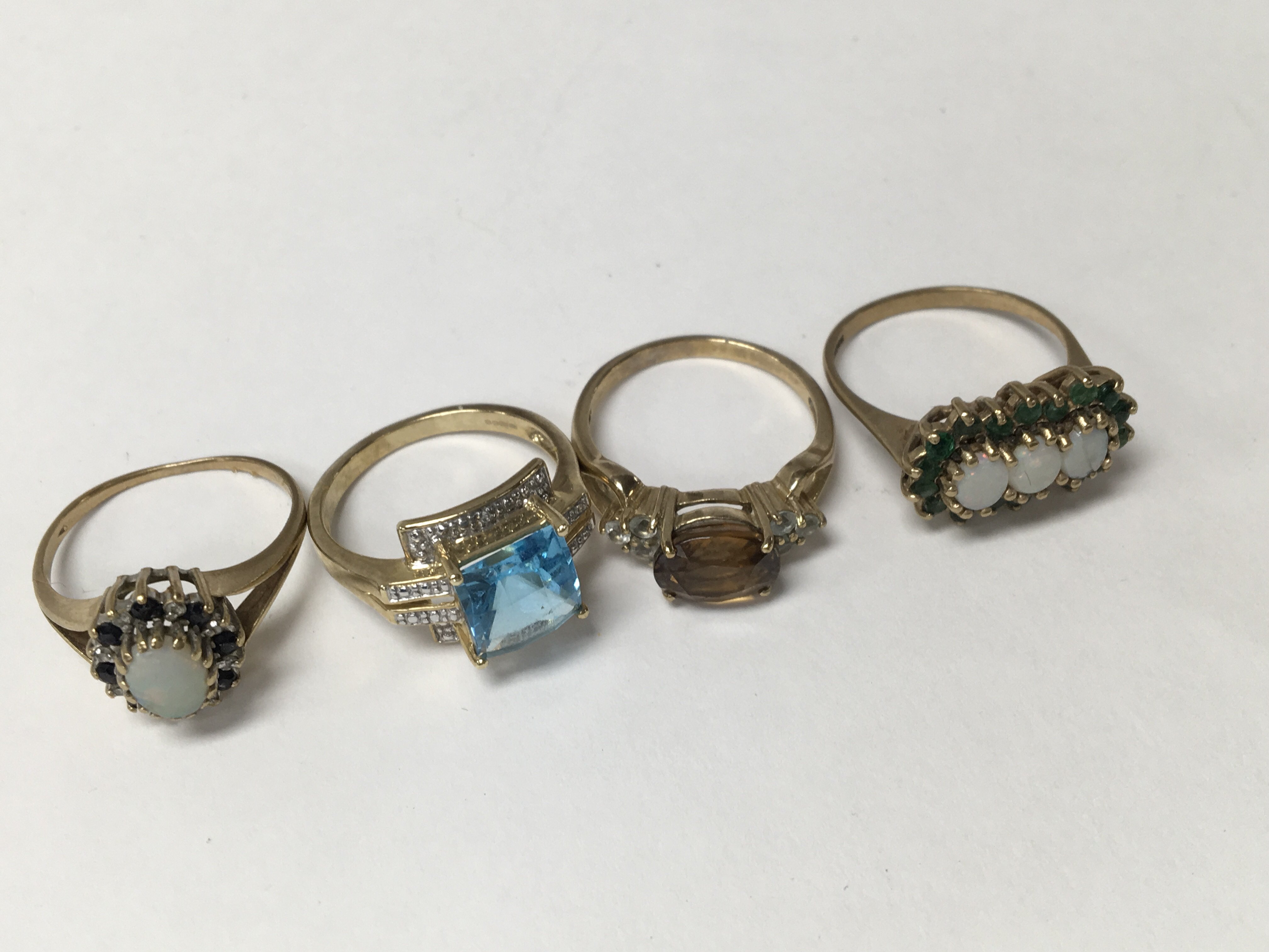 A collection of four rings with 9 ct gold bands