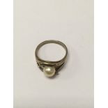 A 9 ct gold ring inset with central pearl