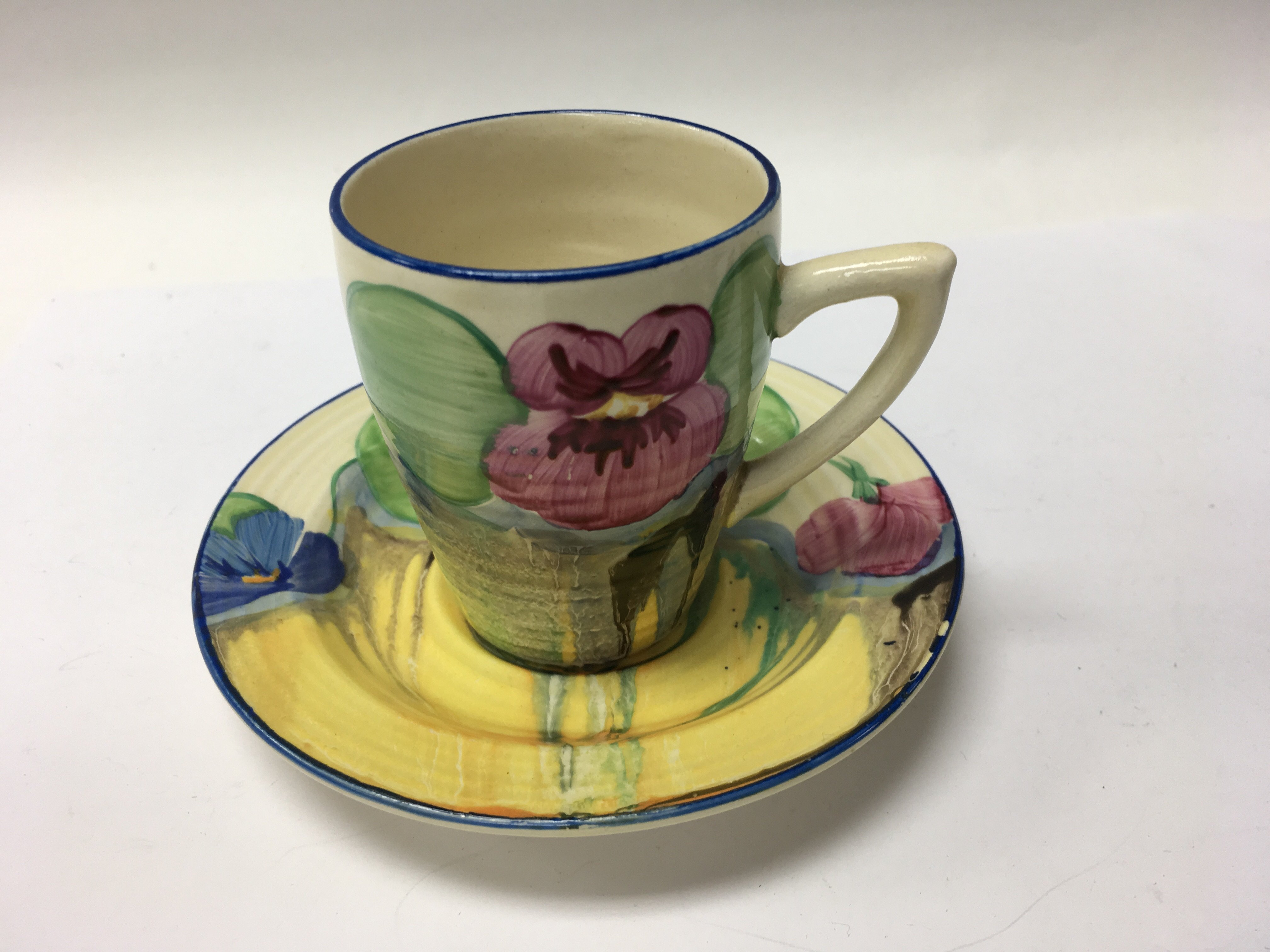 A Clarice Cliff coffee can and saucer decorated wi