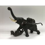 A bronze figural group of an elephant and two tige