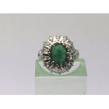 An 18ct white gold ring set with a central emerald