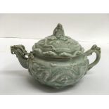 A Chinese celadon teapot, relief decorated with dr
