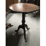 A circular mahogany occasional table with pie crus