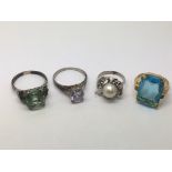 Four costume rings set with stones.