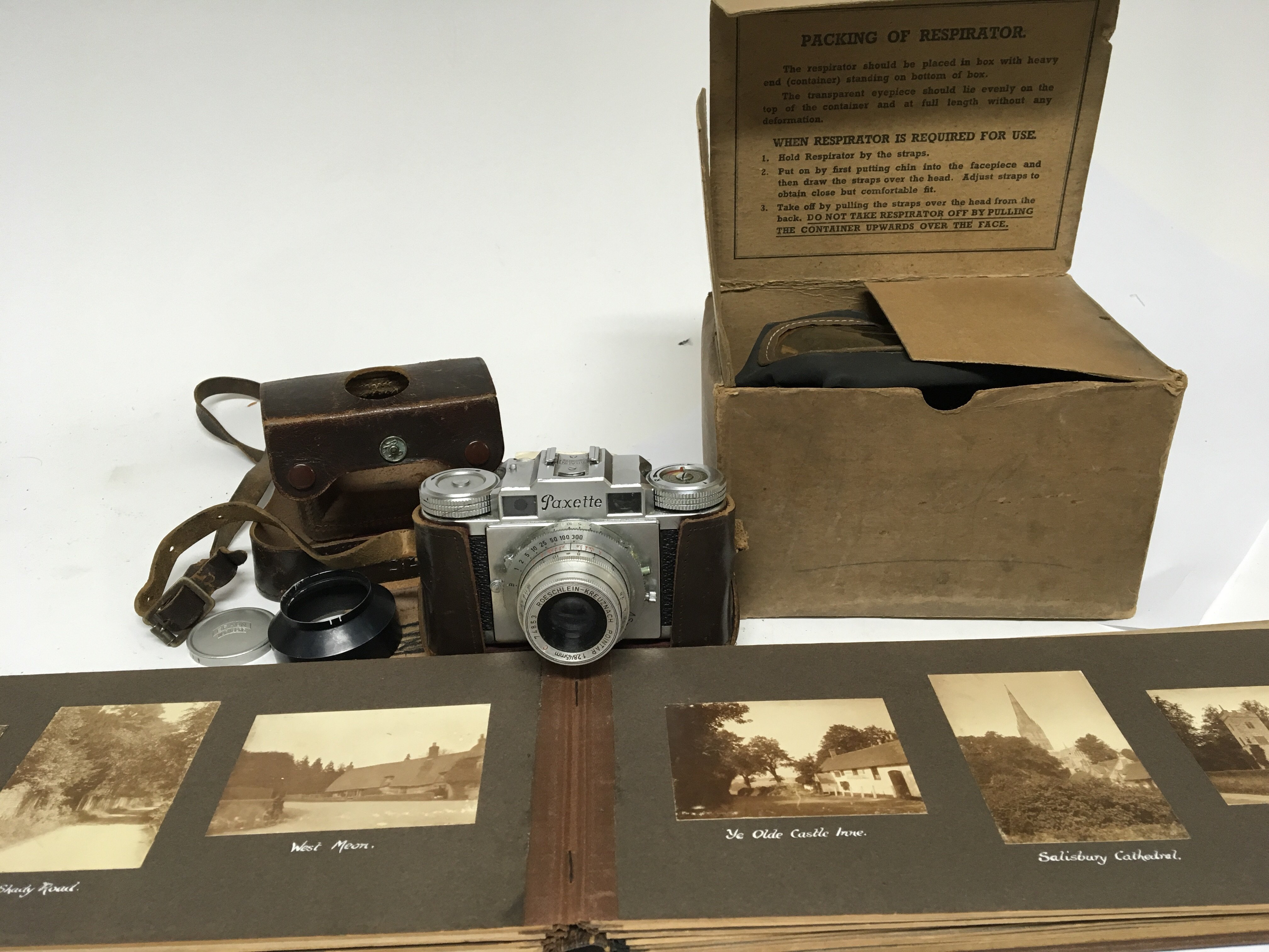 A vintage Baraun Paxette Camera a World War II gas mask and a well present photo album of British