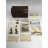 A rosewood box containing various cigarette cards.