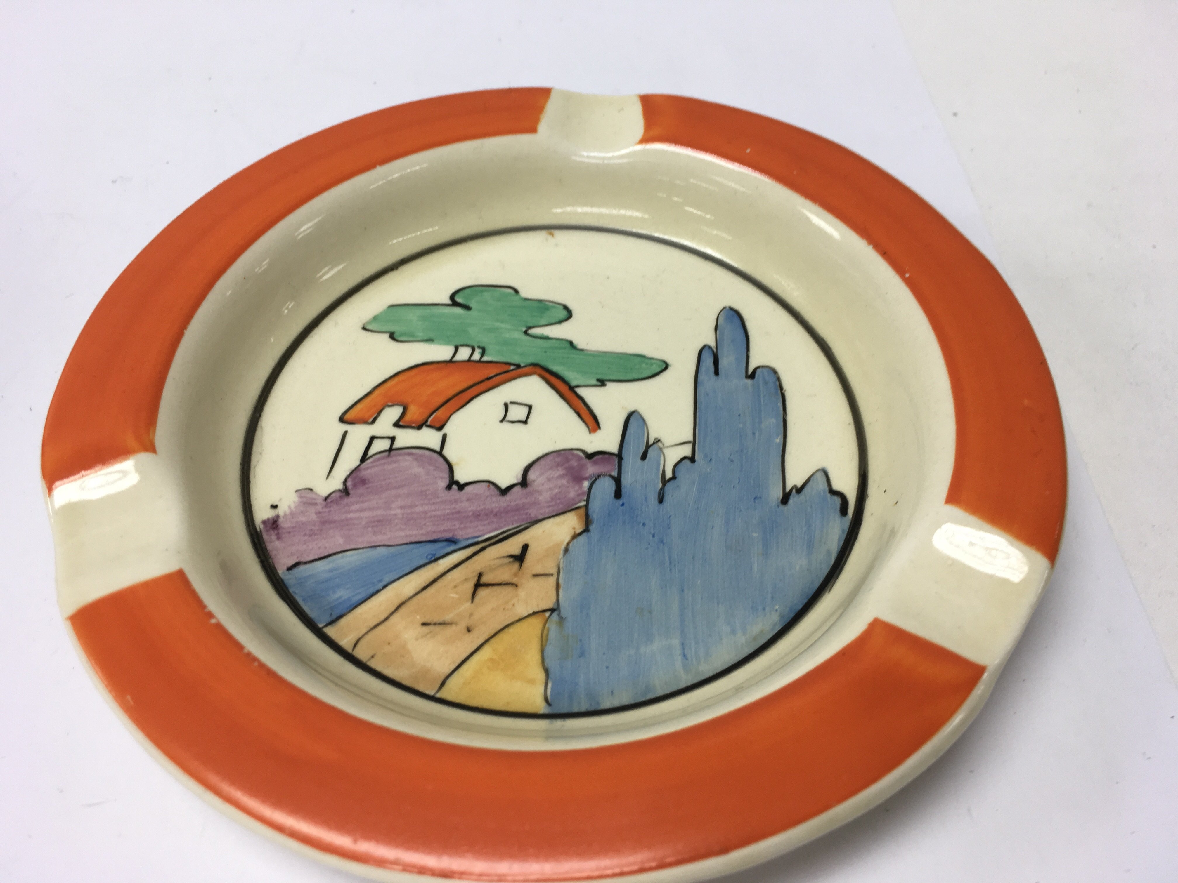 A Clarice Cliff ash tray decorated with house and