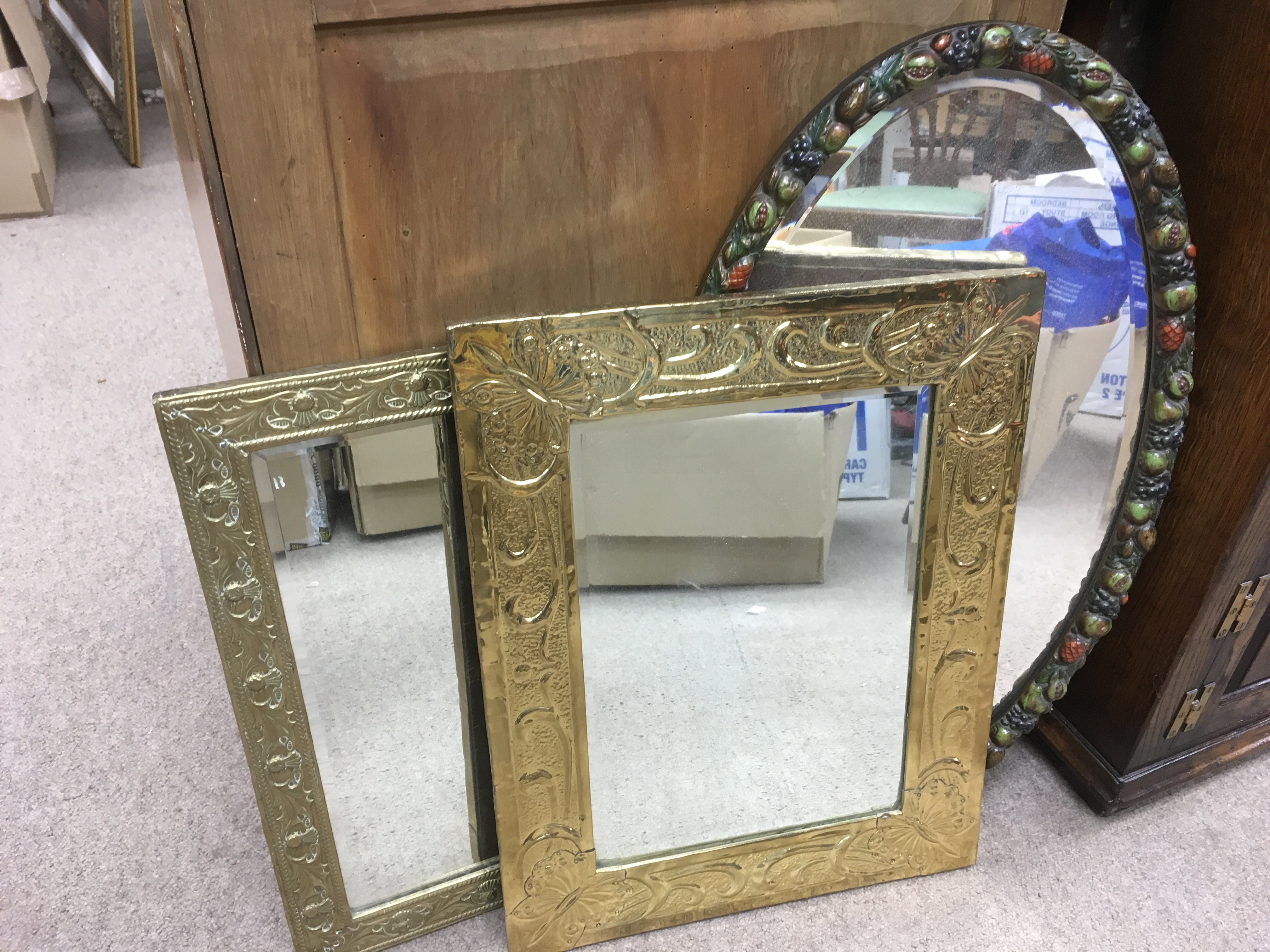 Three wall mirrors comprising a brass framed example, approx heights 78cm, 58cm and 54cm.