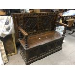 A carved oak hall seat monks bench.