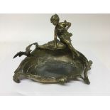 A brass art nouveau dish of shell form surmounted with a bird and maiden