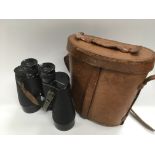 A pair of binoculars in a leather carry case.