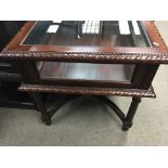 A large reproduction square top display cabinet on turned and fluted legs .