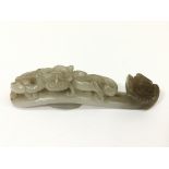 A small carved grey jade of a dragon chasing it's tail. Approx 10cm long.