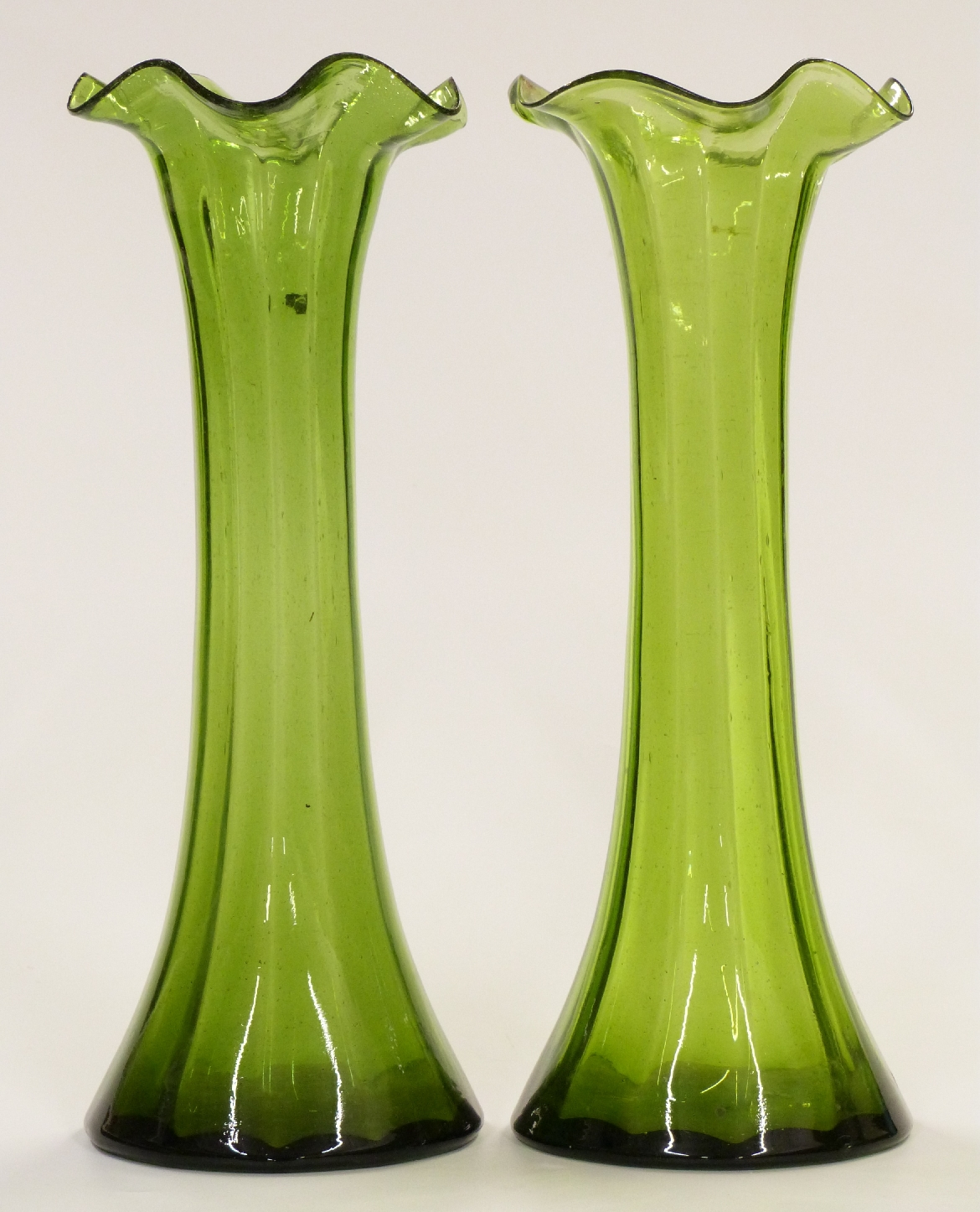 A pair of Art Nouveau green glass vases with frilled rims, 30cm tall.