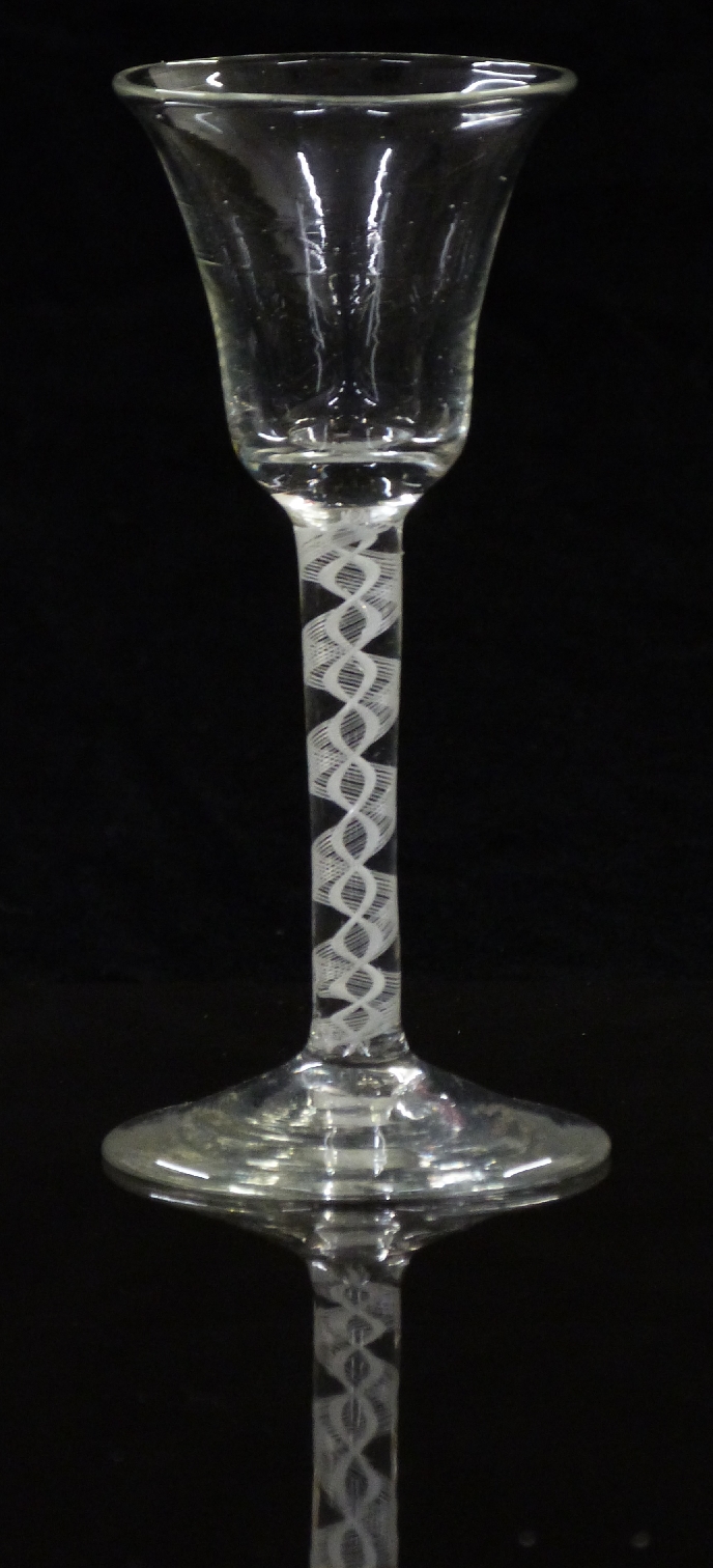 An 18thC clear drinking glass with opaque double twist stem and waisted bowl raised on conical foot,