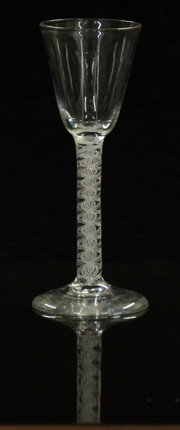 An 18thC clear drinking glass with opaque double twist stem and ogee shaped bowl raised on conical