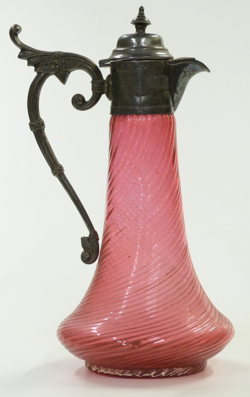 Cranberry glass water jug with wrythen molded body and silver plated mounts, 29cm tall.
