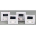 Four white Creston APAD wall mounted LCD controllers for Creston's Adagio home entertainment system,