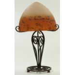 Degue mottled glass lamp raised on wrought iron base with scrolling decoration, 39cm tall.