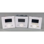 Three white Creston APAD wall mounted LCD controllers for Creston's Adagio home entertainment