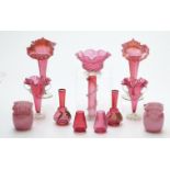 Twelve cranberry glass vases including two pairs with crimped rims, two with gilded decoration and a