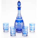 Flash overlaid cut glass drinking set comprising a decanter and four cups with blue overlay over a