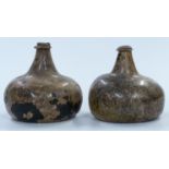 A near pair of early 18thC green glass onion wine bottles with iridescent finish, by repute dug up