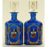 A pair of blue glass armorial decanters with gilded and enamelled decoration, height 26cm